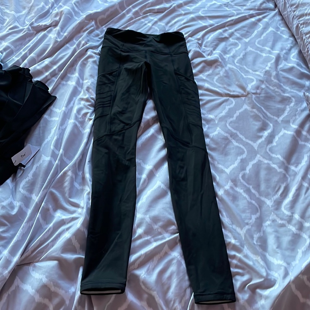 Size 2 Lululemon leggings with side pockets, reflective ankle & zipper on waist.